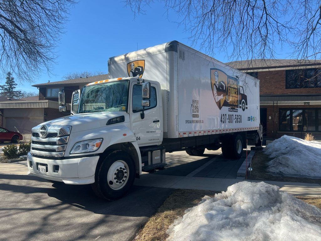 Special Force Movers moving truck parked outside a residential home in Ontario during winter.